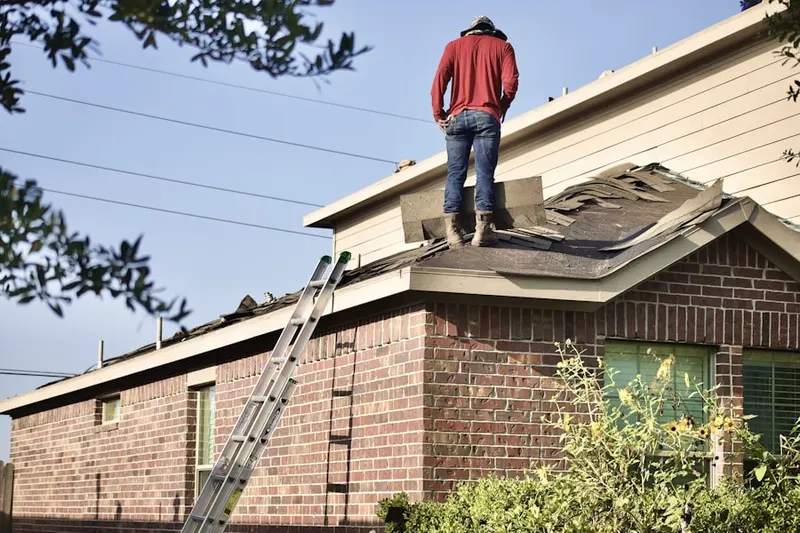 Professional roofer working on a residential roof in Newton